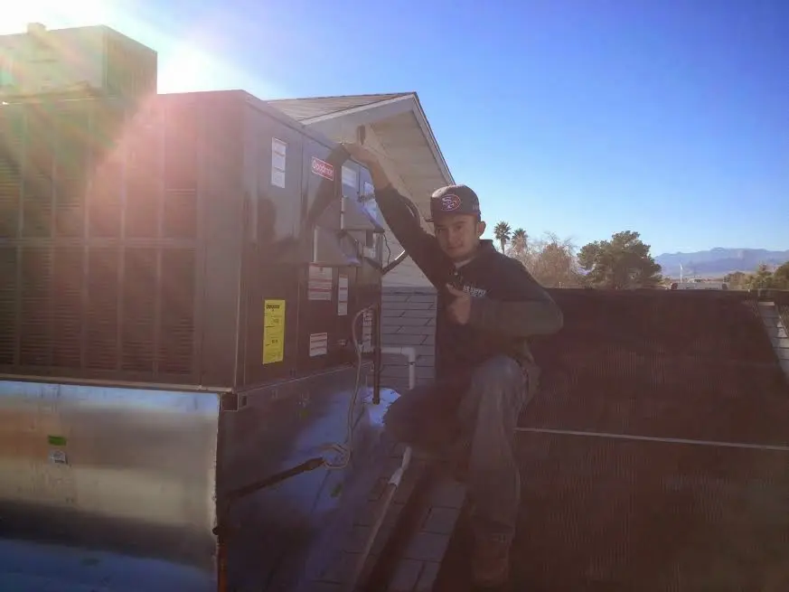 HVAC technician performing AC Tune-Up on a rooftop unit in Lake Park